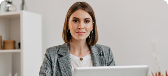 business-woman-in-checkered-jacket-with-smile-while-sitting-at-desk-in-her-office